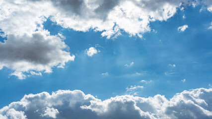 Obraz premium Background of backlit Cumulus white clouds bodies floating in clear blue sky