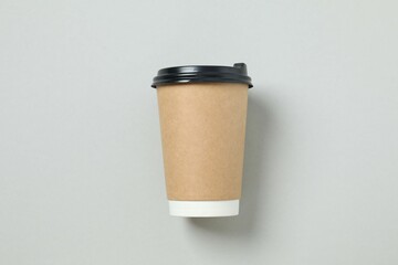Paper cup of coffee on gray background