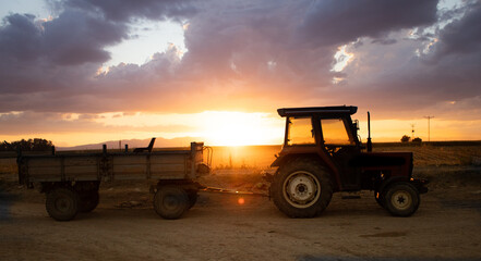 magnificent sunset and tractor view in agricultural field