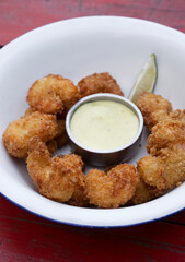 Top view of fried breaded shrimps with avocado mayonnaise and lemon.