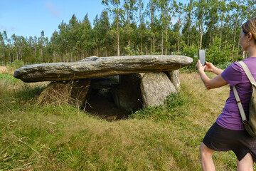 Tourist taking photos of a dolmen in Galicia