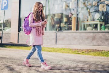 Full size photo of pretty young girl use smart phone outerwear coat walk city center street outdoors