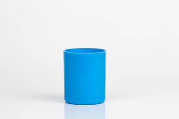 Cyan plastic cylindrical cap, cylinder shaped object, hollow side up, isolated on white background.