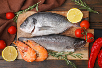 Fresh raw sea food and products on wooden table, flat lay