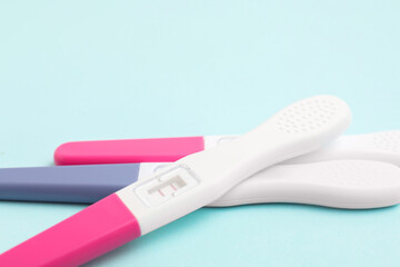 Pregnancy tests on light blue background, closeup