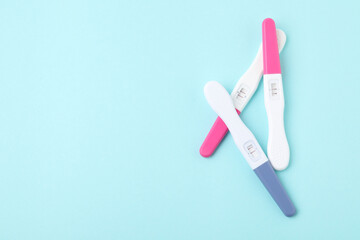 Pregnancy tests on light blue background, top view. Space for text