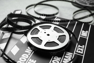 Movie clapper and film reel on table, closeup