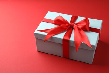 Gift box with bow on red background