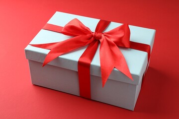 Gift box with bow on red background