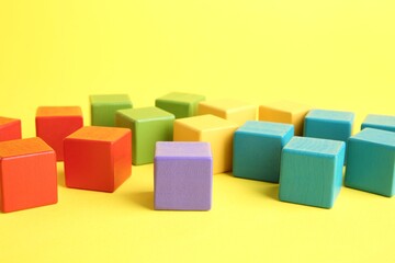 Obraz premium Many wooden colorful cubes on yellow background