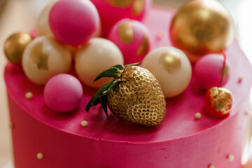 Colorful Pink Cake Topped with Gold and Strawberry Decorations