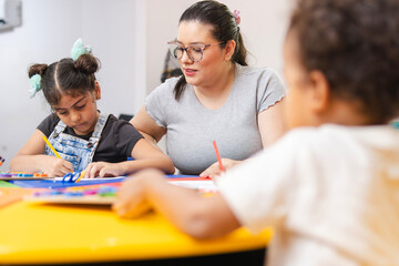 A Colombian Latina preschool teacher teaching and supporting her students with classroom projects