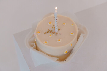 Celebratory Birthday Cake with Candle and Floral Decorations