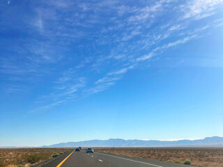 Open road with mountain range and bright blue sky