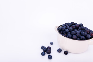 Blueberries in a small ceramic pot on an infinite white background, showcasing fresh and healthy fruit in a clean, minimalist composition