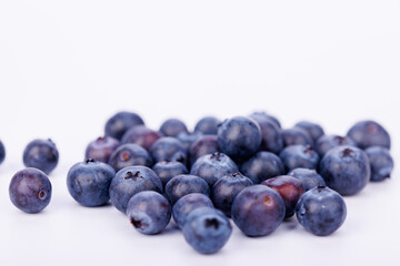 Stunning close-up of blueberries piled together on a clean white background, emphasizing their natural beauty and juicy texture in detail