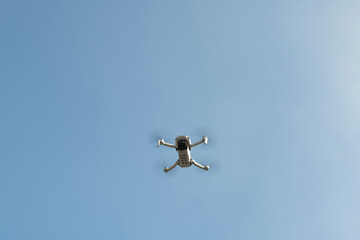 The drone flies against the blue sky	