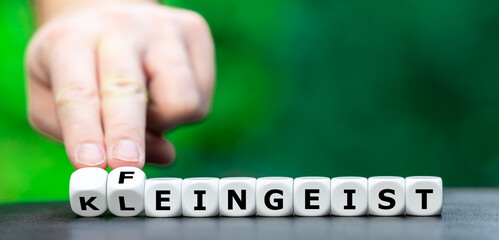Hand dreht Würfel und ändert den Ausdruck Kleingeist in Feingeist.