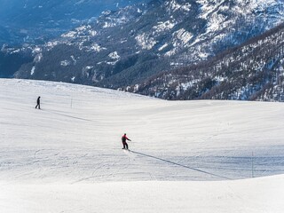 Skiers on snowy mountain slope with scenic landscape