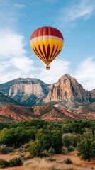 Obraz premium The vibrant hot air balloon ascends into the blue sky above the expansive desert terrain of Wadi Rum, showcasing rugged mountains and sandy vistas