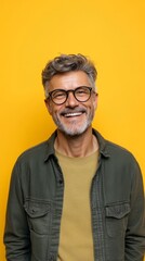 Obraz premium Joyful Mature Man Smiling Against Yellow Background
