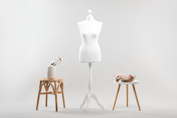 Mannequin, vase and stools on light grey background