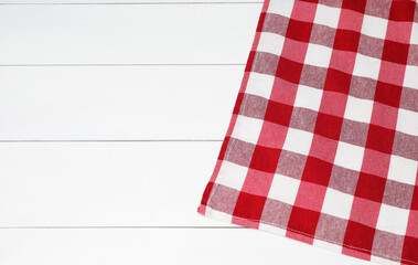 Fototapeta premium Tablecloth with checkered pattern on white wooden table, top view. Space for text