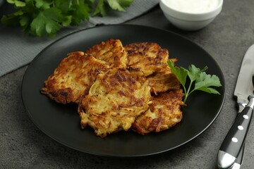 Delicious potato pancakes served on grey table, closeup