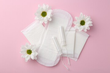 Flat lay composition with menstrual products on pink background