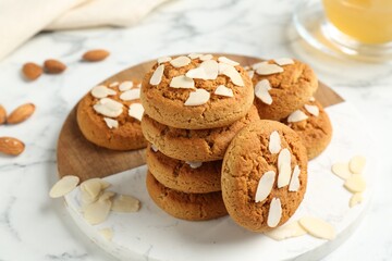 Tasty cookies with almond flakes on white marble table, closeup