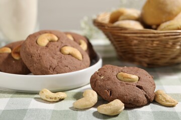 Tasty chocolate cookies with cashew on table, closeup