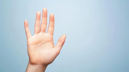 A human hand showing an open palm against a light blue background
