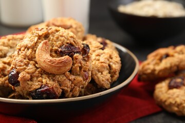 Delicious oatmeal cookies with raisins and nuts on table, closeup