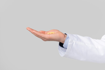 Closeup of male doctor's hand ponting or holding virtual object on open palm over white studio...