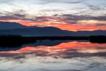 Sunrise over the lake with orange and red hues mixed in for a gorgeous image