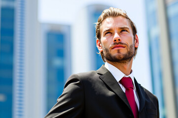 Businessman looking up to the sky with optimism in the city
