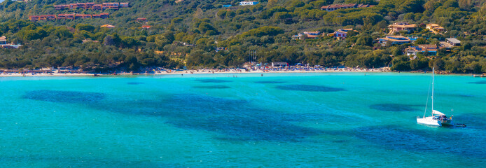 Aerial view of a Sardinian beach in Italy, featuring turquoise waters, a white sandy shore, a...