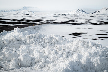 Snow piled along road in winter mountain landscape