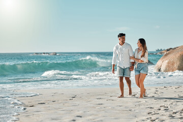 Walking, space or happy couple at sea holding hands for love on vacation, anniversary or holiday. Smile, talking or people at beach for bonding together for ocean trip adventure or mockup in Spain