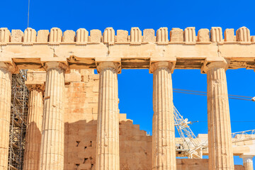 The columns are made of stone and are part of a building