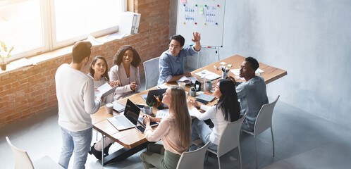 Multiracial group of people having business meeting discussion in loft style office, high angle view