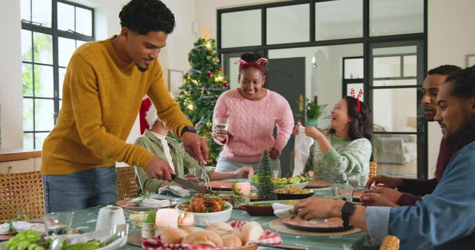 Sharing laughter at festive Christmas dinner, diverse friends celebrating holiday together