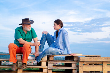 Grandchild girl and grandad talking. Daughter and old father talking outdoor. Caring for older...