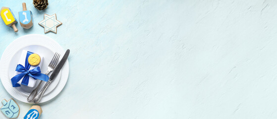 Festive table setting with Hanukkah decorations on light blue background