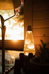 Lava lamp glowing in the golden sunset in a retro cabin
