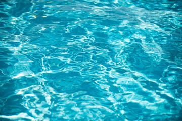 Water background, ripple waves. Blue swiming pool pattern. Sea surface. Water in swimming pool with sun reflection. Banner with copy space.