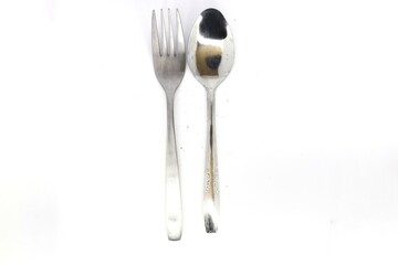 A flatlay of a fork and a spoon on a white surface. Both utensils are made of stainless steel and have a clean, modern design.