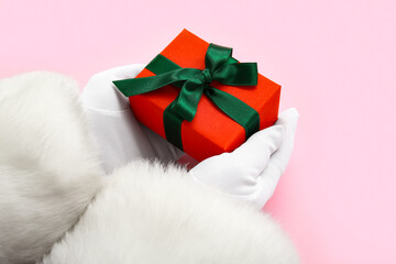 Santa Claus with Christmas gift box on pink background