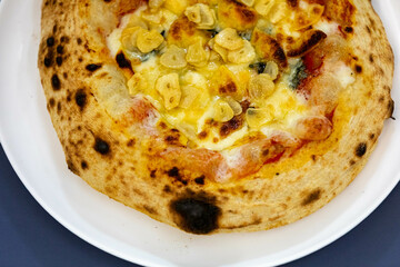 Traditional rustic pizza made with four cheeses, garlic and oil and pear with gorgonzola