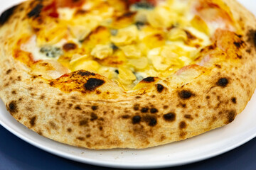 Traditional rustic pizza made with four cheeses, garlic and oil and pear with gorgonzola